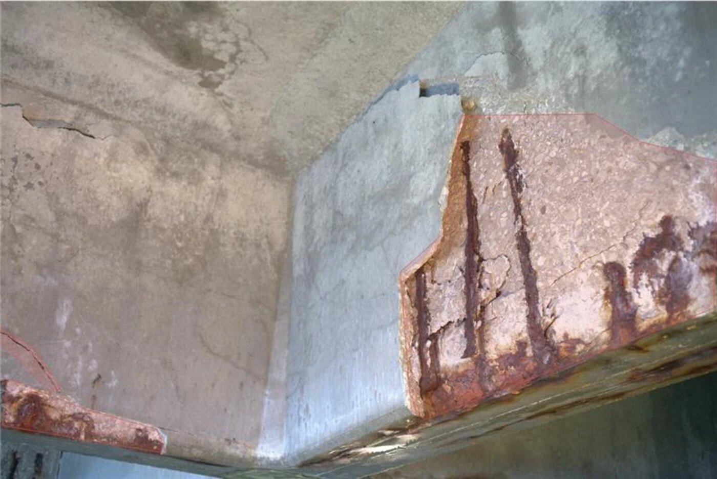 Spalled concrete with exposed, corroded reinforcement
